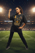 A black acid-wash graphic t-shirt featuring a raccoon mascot holding a football and foam finger with the text 'football season' in gold script.